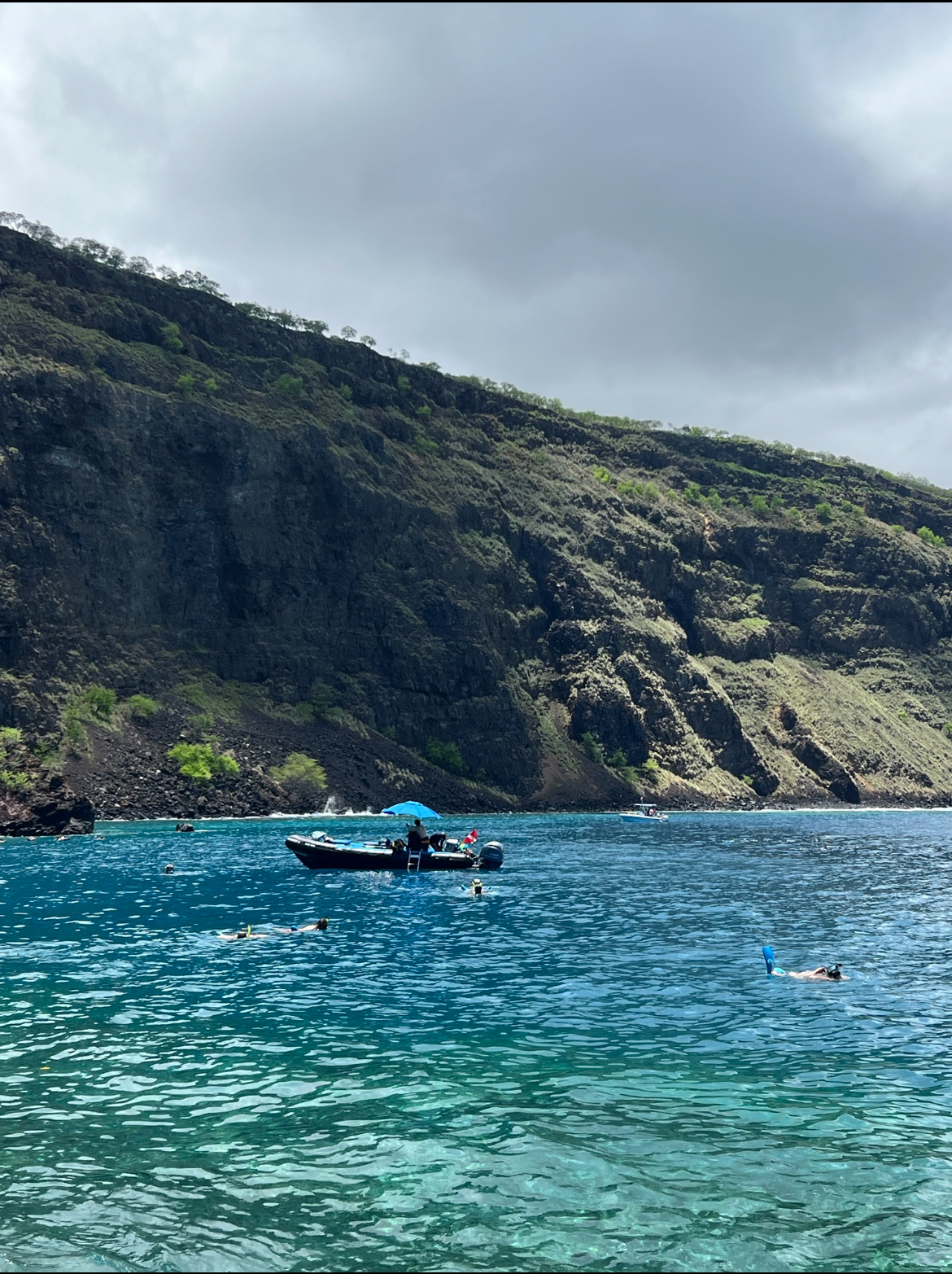 IMG_1880 a small boat in a body of water with a mountain in the background